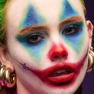 Look clown di Halloween di NYX Professional Makeup con colorato trucco occhi blu, giallo e rosso, naso rosso e labbra rosse.