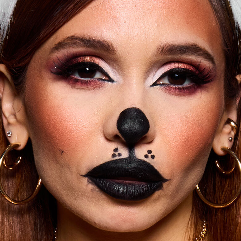 Look cagnolino di Halloween di NYX Professional Makeup con trucco marrone sul naso, orecchie nere, dettagli del muso bianchi e labbra dipinte di nero.
