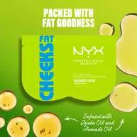 Maschera in tessuto per i glutei NYX Professional Makeup Fat Cheeks (Coconut Cutie) su sfondo verde acceso con goccioline d'olio. Il testo evidenzia una formula ricca di ingredienti nutrienti, infusa con olio di jojoba e olio di avocado.