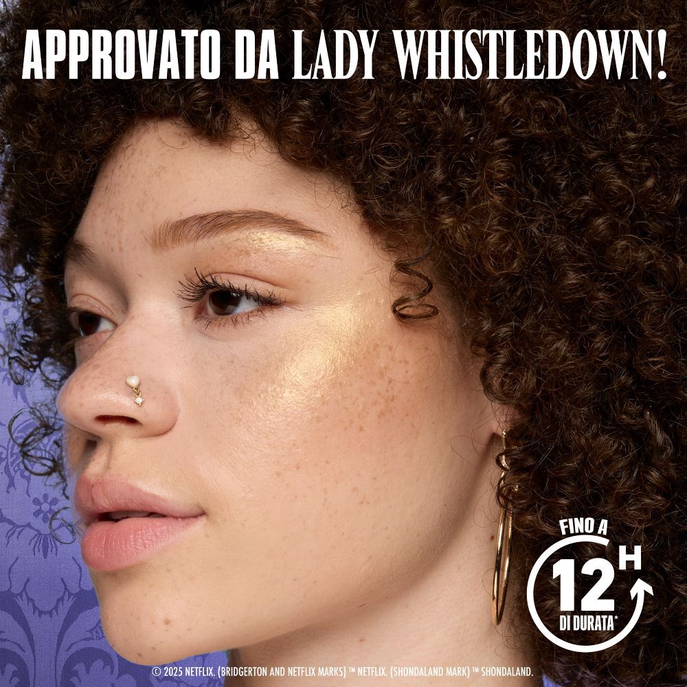 Modella indossa illuminante NYX Professional Makeup Bridgerton Royal su guancia, luminosita naturale. 'APPROVATO DA WHISTLEDOWN!', 'fino a 12 ORE' (orologio), 'BRILLA COME IL NUOVO DIAMANTE DELLA STAGIONE!' (01 Iridescent Peach).