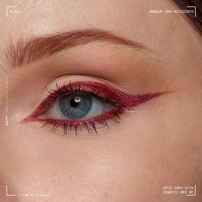 Close of a model wearing Epic Inky Stix on the top of their eyelid as a winged liner style in shade 04 Robotic Red