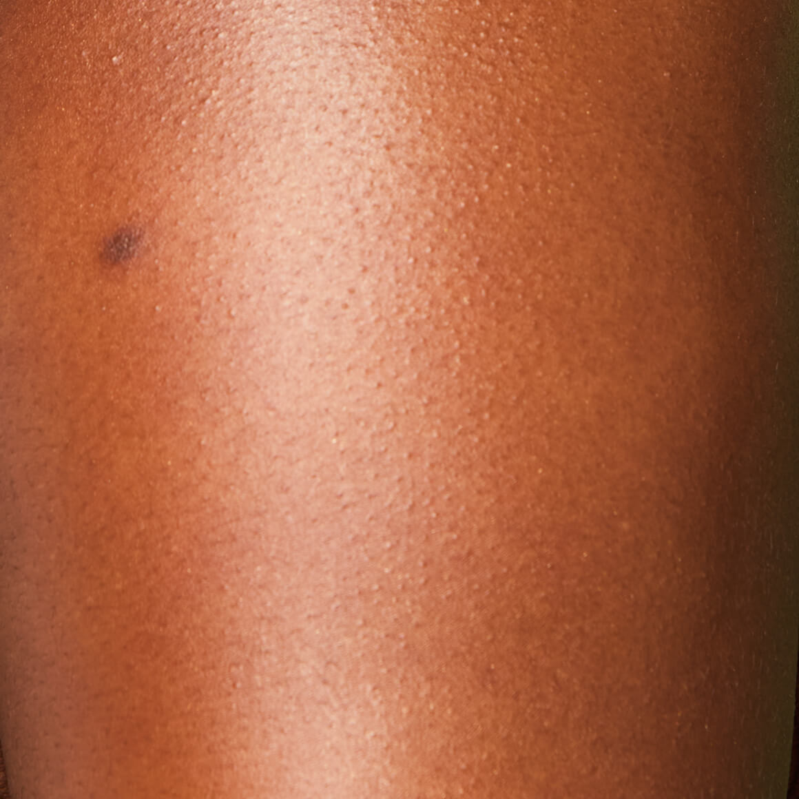 Image of the model’s arm after applying NYX Professional Makeup Caramelt Mami Body Butter giving a golden, glowy finish.